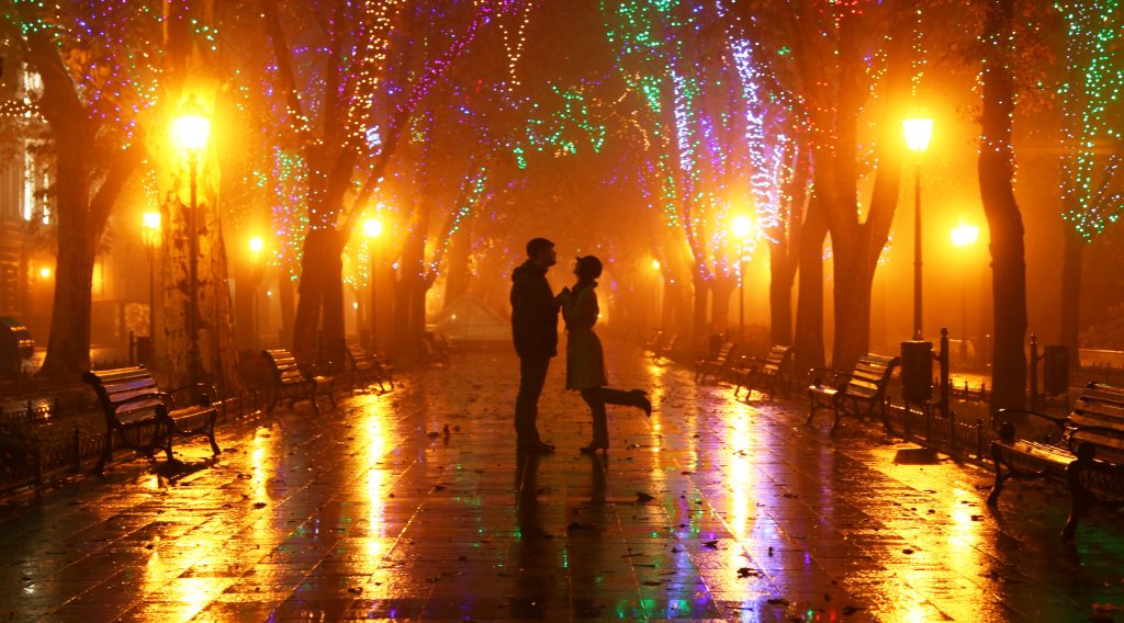 Couple walking at alley in night lights